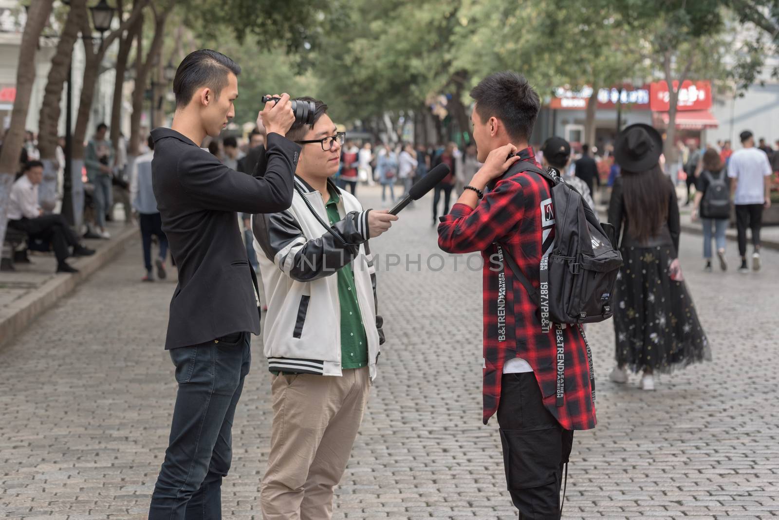 Harbin, Heilongjiang, China - September 2018: Filming interview. Blogger writes video report