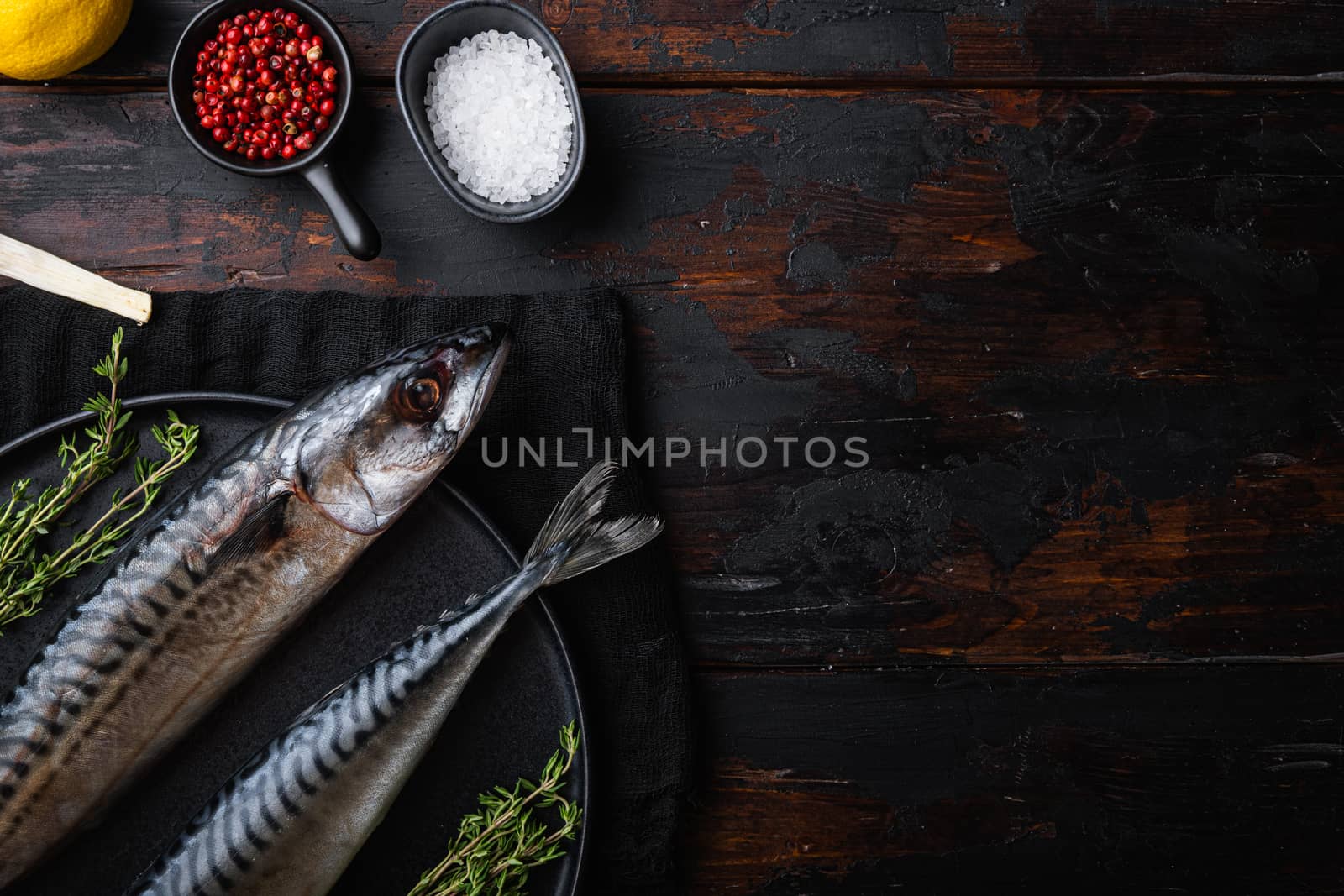 Raw whole sea fish with ingredients on wooden table, flat lay with space for text.