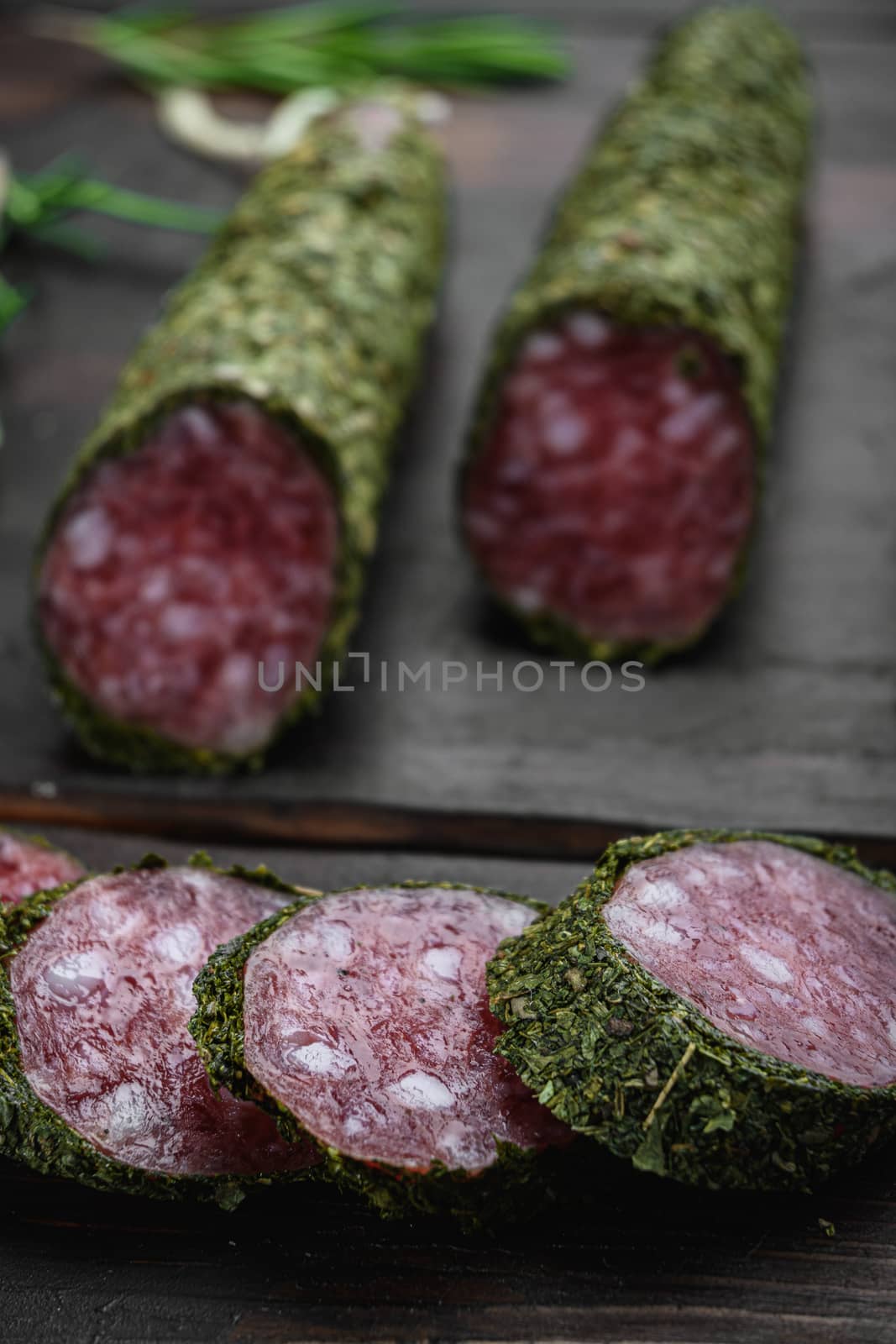 Traditional sausage salami fuet, cut to slices on old wooden table.