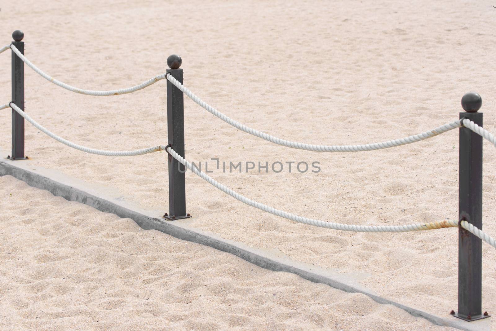 Rope fence on the sandy beach. Prohibition of passage