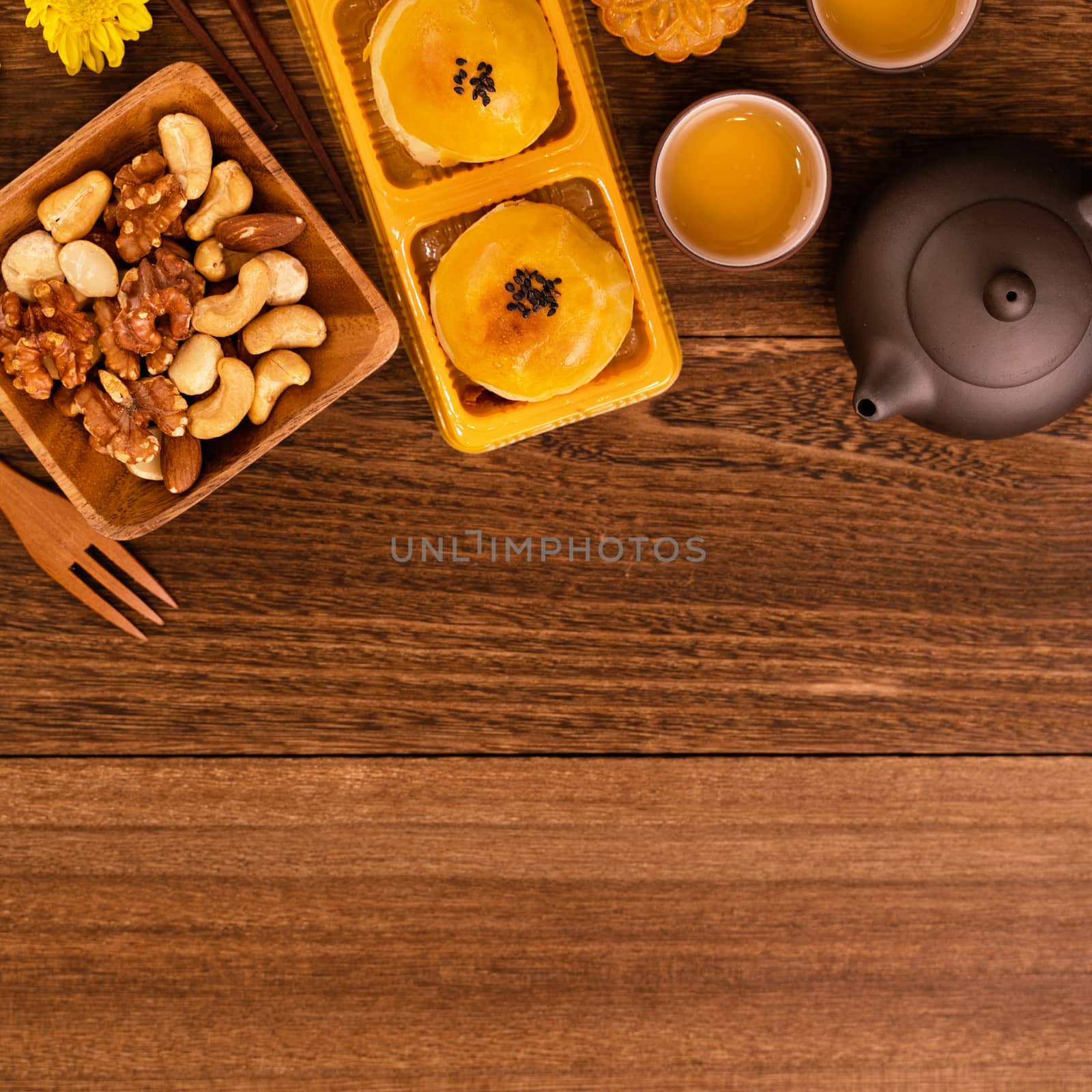 Moon cake for Mid-Autumn Festival, delicious beautiful fresh mooncake on a plate over dark wooden background table, top view, flat lay layout design concept.