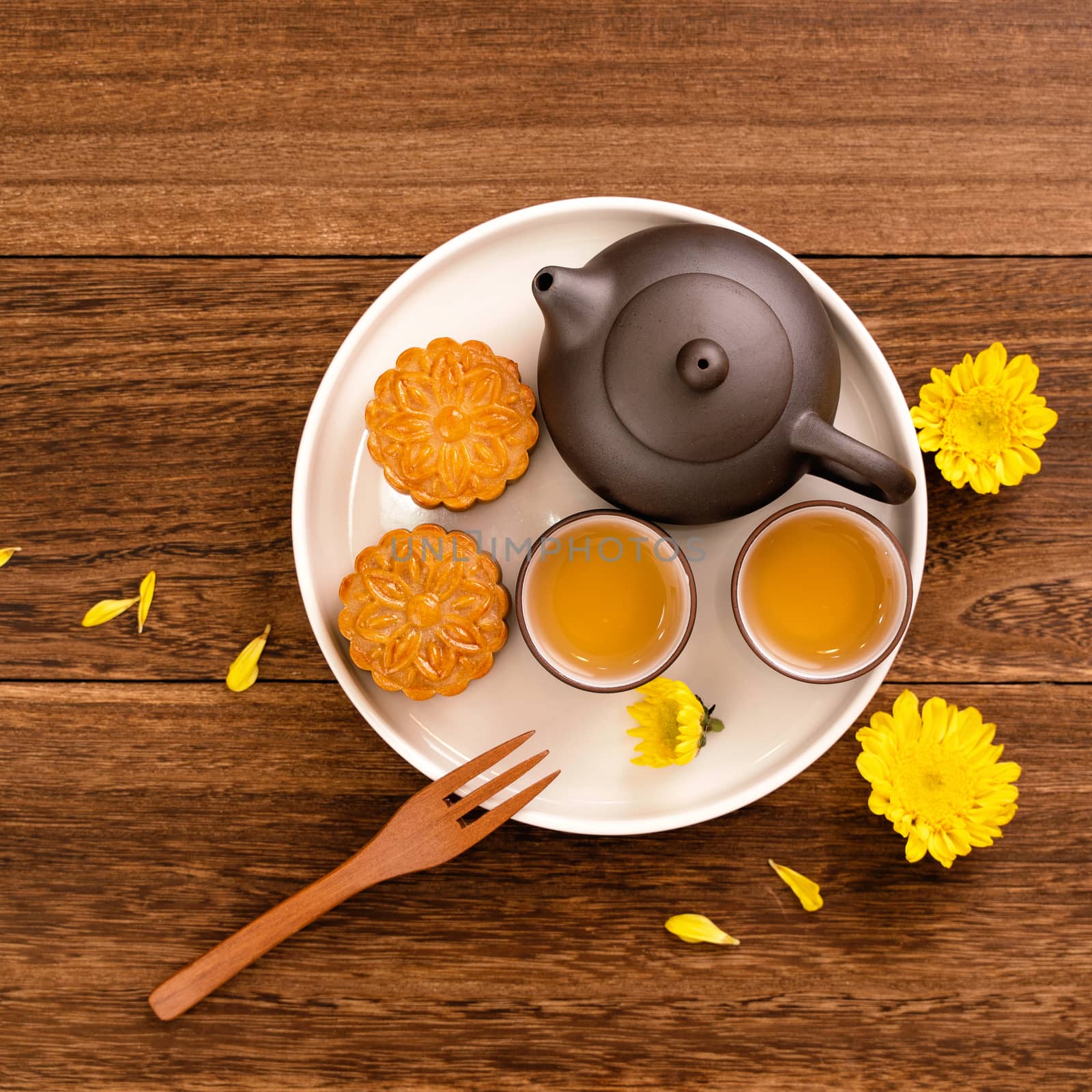 Moon cake for Mid-Autumn Festival, delicious beautiful fresh mooncake on a plate over dark wooden background table, top view, flat lay layout design concept.