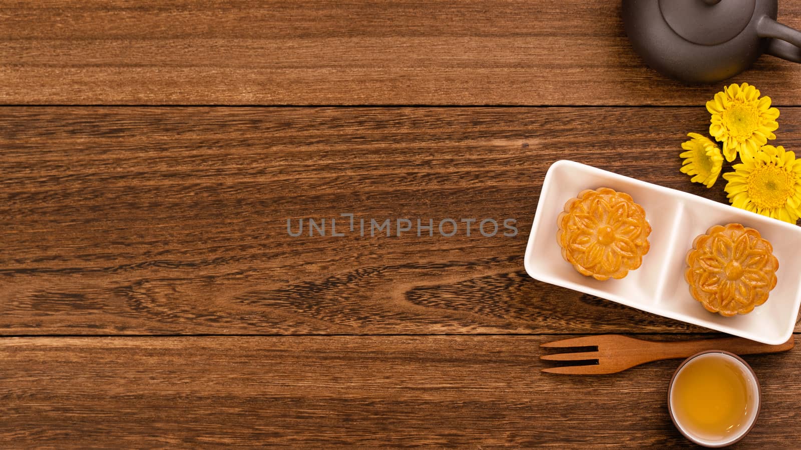 Moon cake for Mid-Autumn Festival, delicious beautiful fresh mooncake on a plate over dark wooden background table, top view, flat lay layout design concept.