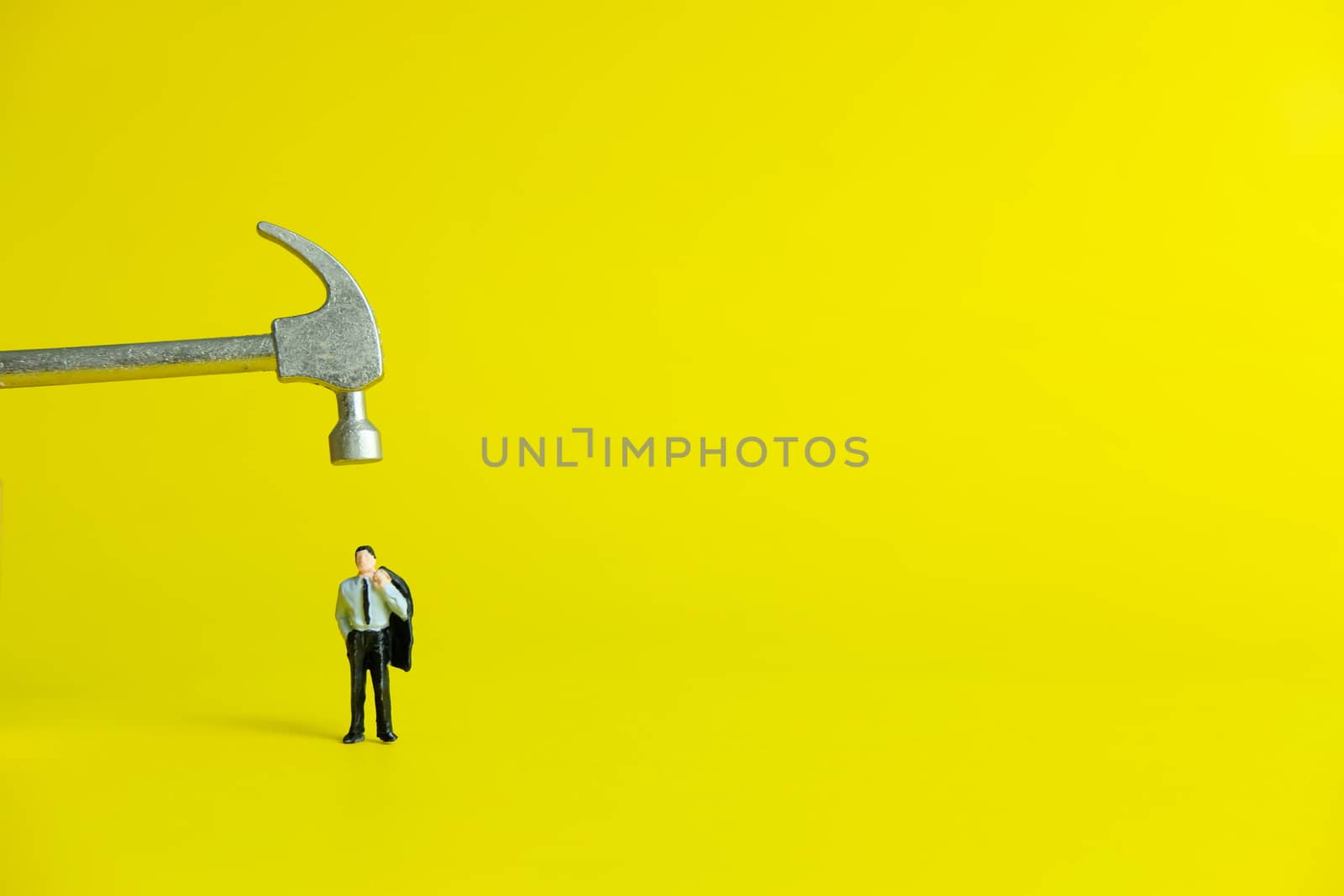 Miniature people concept - desperately businessman (workload shown by the hammer)