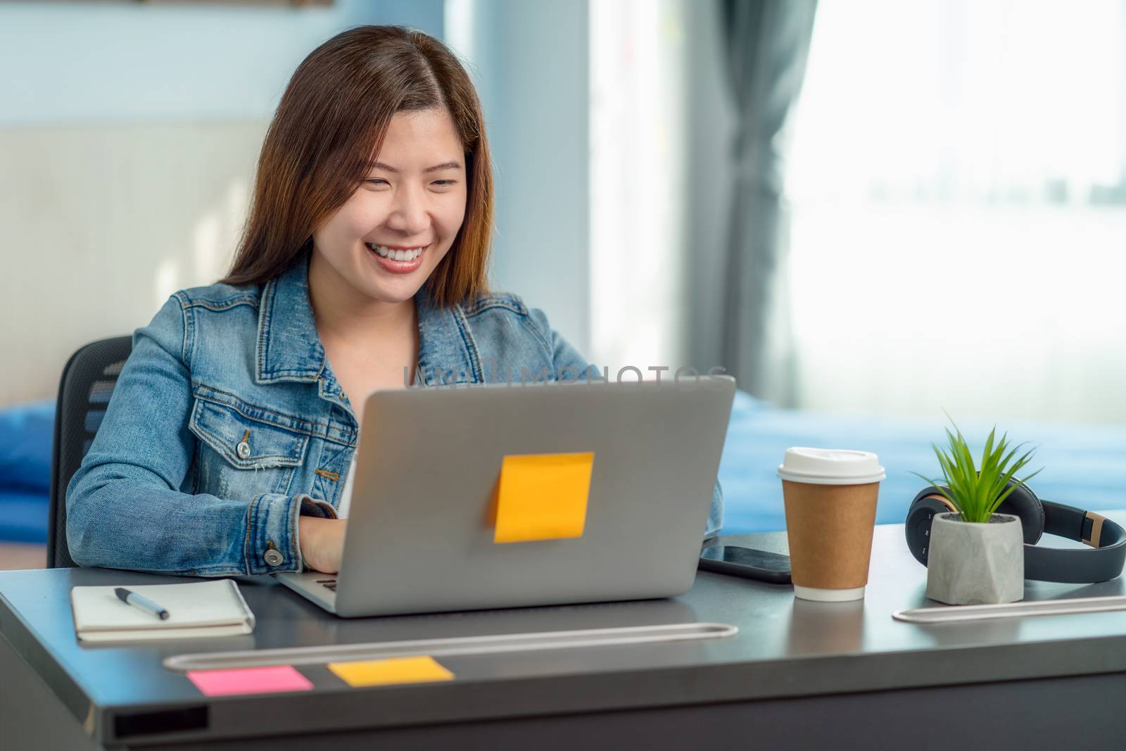 Asian business woman using technology laptop and working from home in indoor bedroom of house by video conference call,startups and business owner,social distance and covid outbreak new normal concept