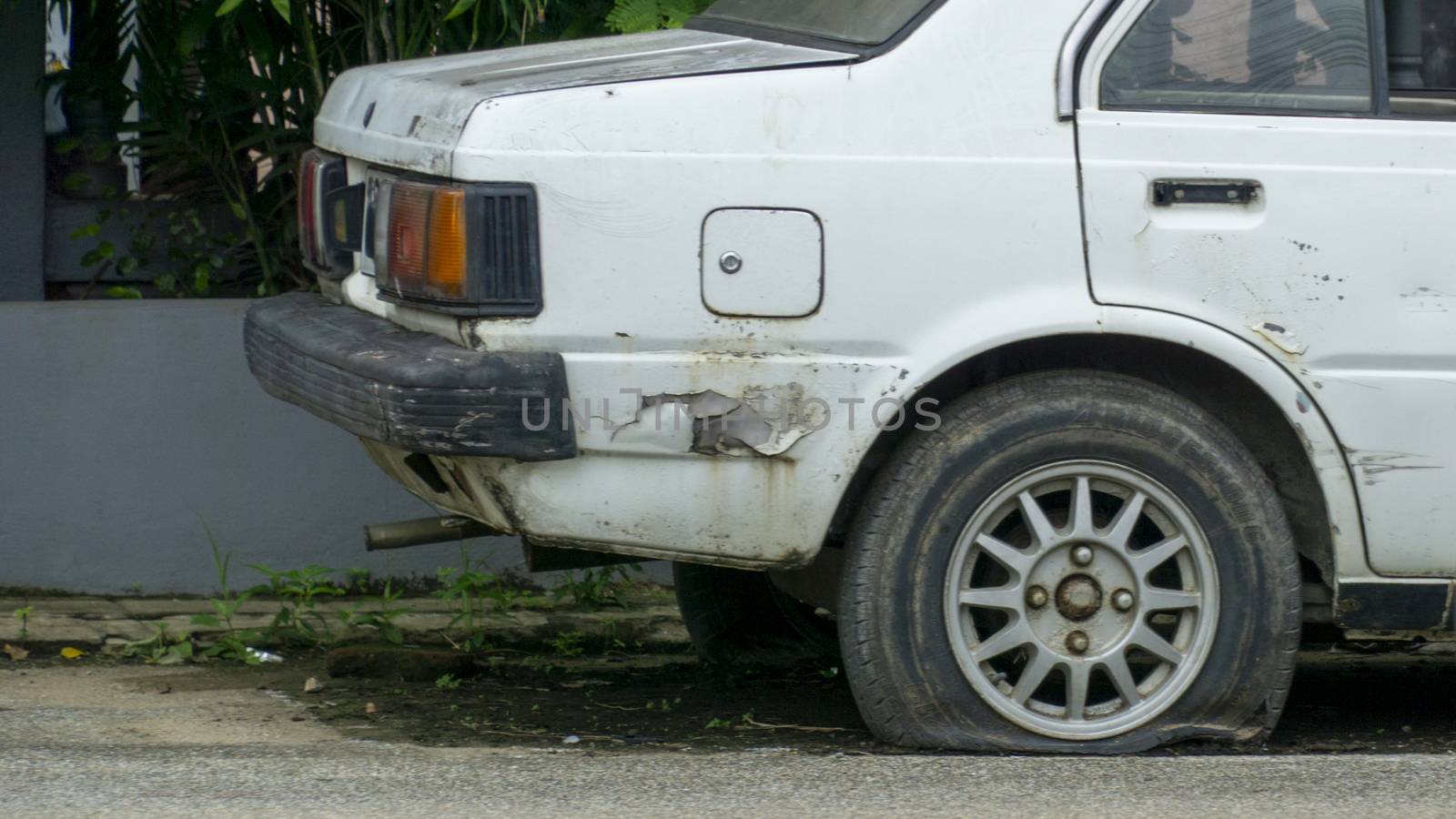 Old worn out and rusted abandoned car with flat tyre by sonandonures