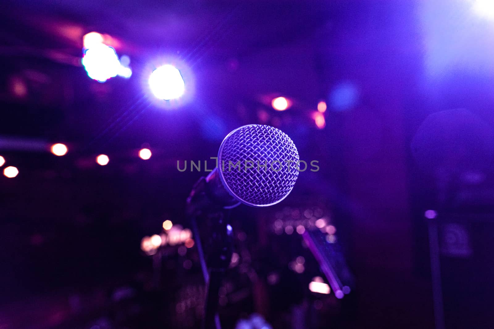 the microphone of a star on a stand in a hall with many multicolored lights