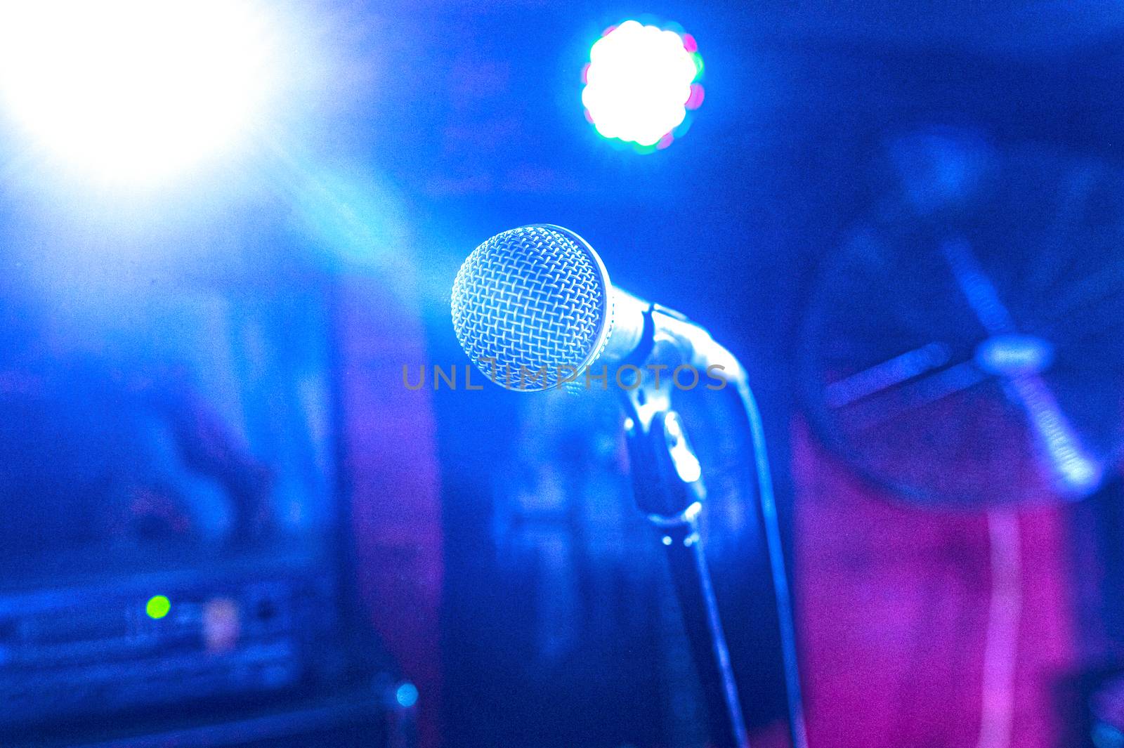 vocal microphone in a set of spotlights on a concert stage in a club by chernobrovin