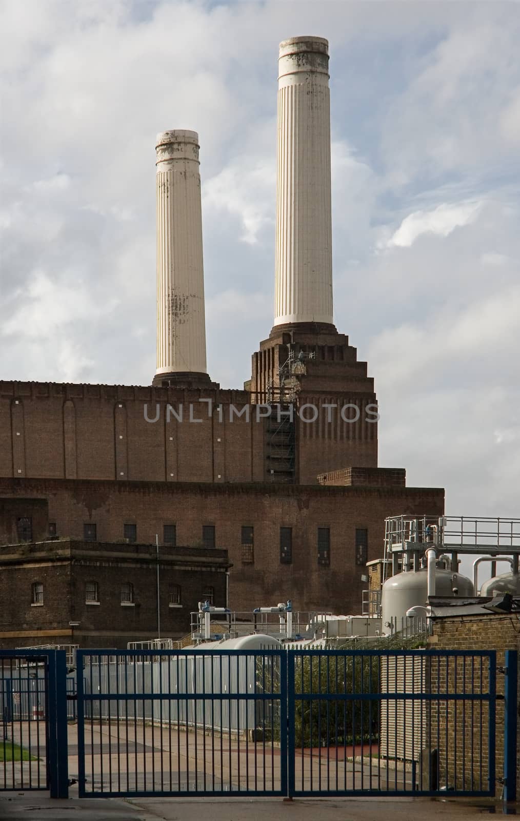 London, United Kingdom - October 01, 2006: Empty entrance of decommissioned (in 1983) coal Battersea power station with two of iconic four white chimneys  on a sunny day.