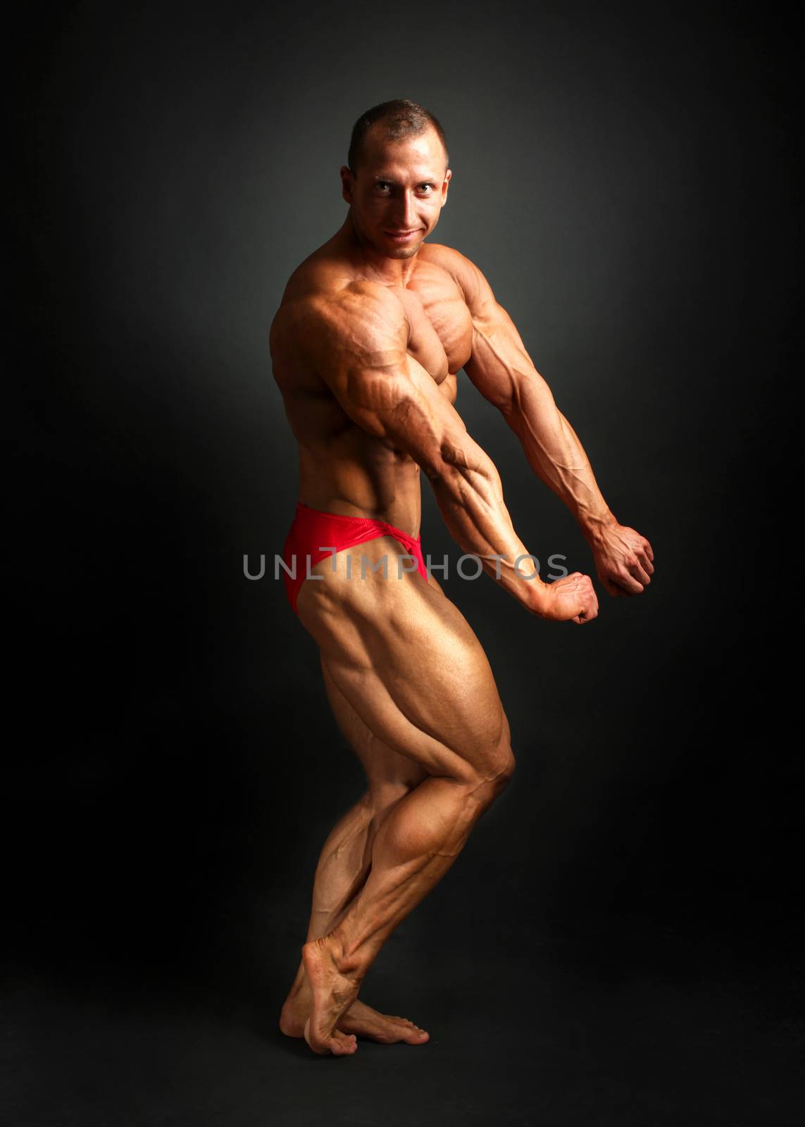 Studio shot of male bodybuilder posing, showing front and side m by Ivanko