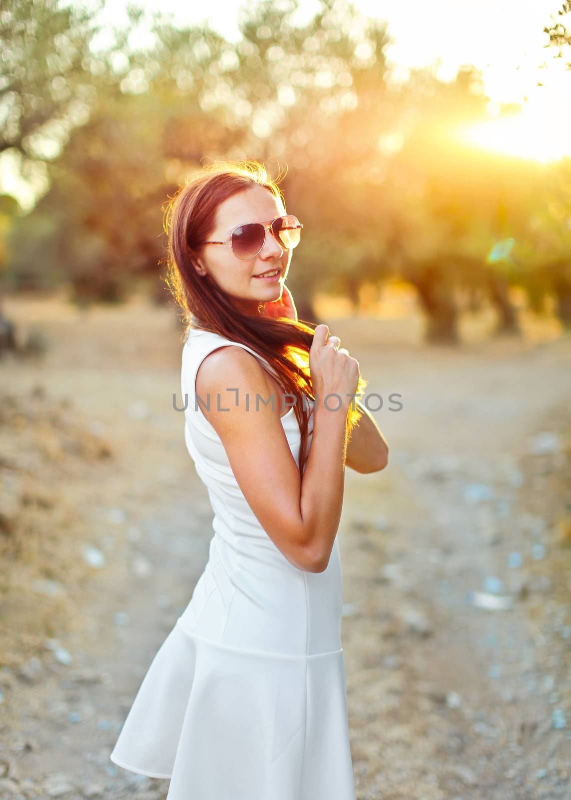 Young woman in white summer dress, wearing sunglasses, playing w by Ivanko