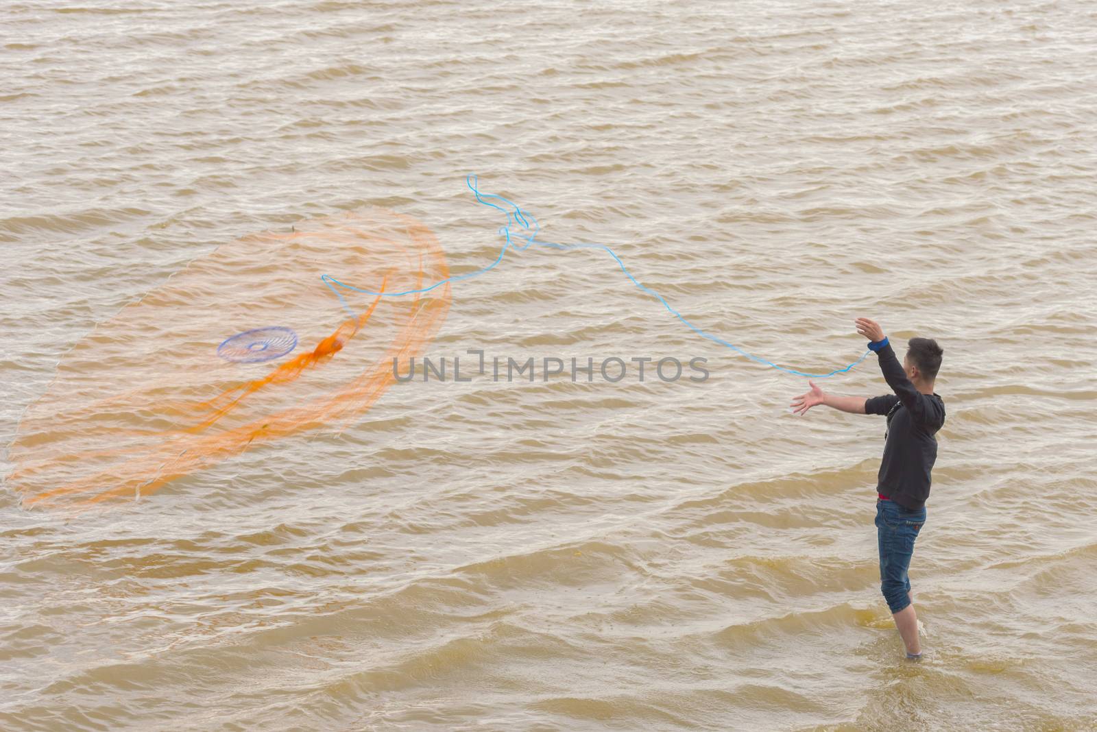 Asian fisherman casting a net for catching freshwater fish. Fisherman on the river. Fishing on the lake. Fishing net