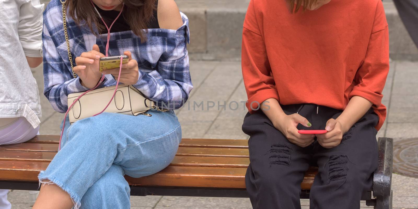 Woman using smart phone. Girls look at smartphones. Girl with phone