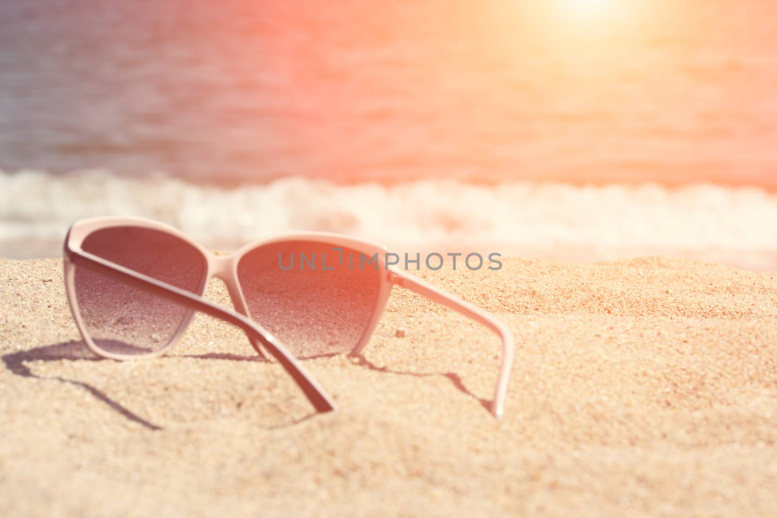 Glasses on the beach sand. Glasses on a background of sea waves