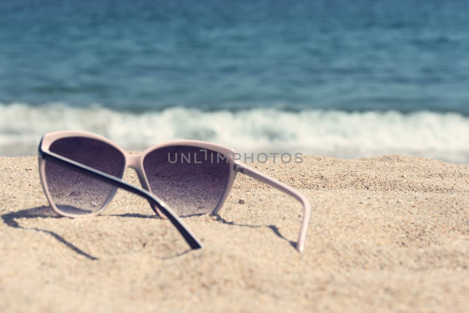 Glasses on the beach sand. Glasses on a background of sea waves
