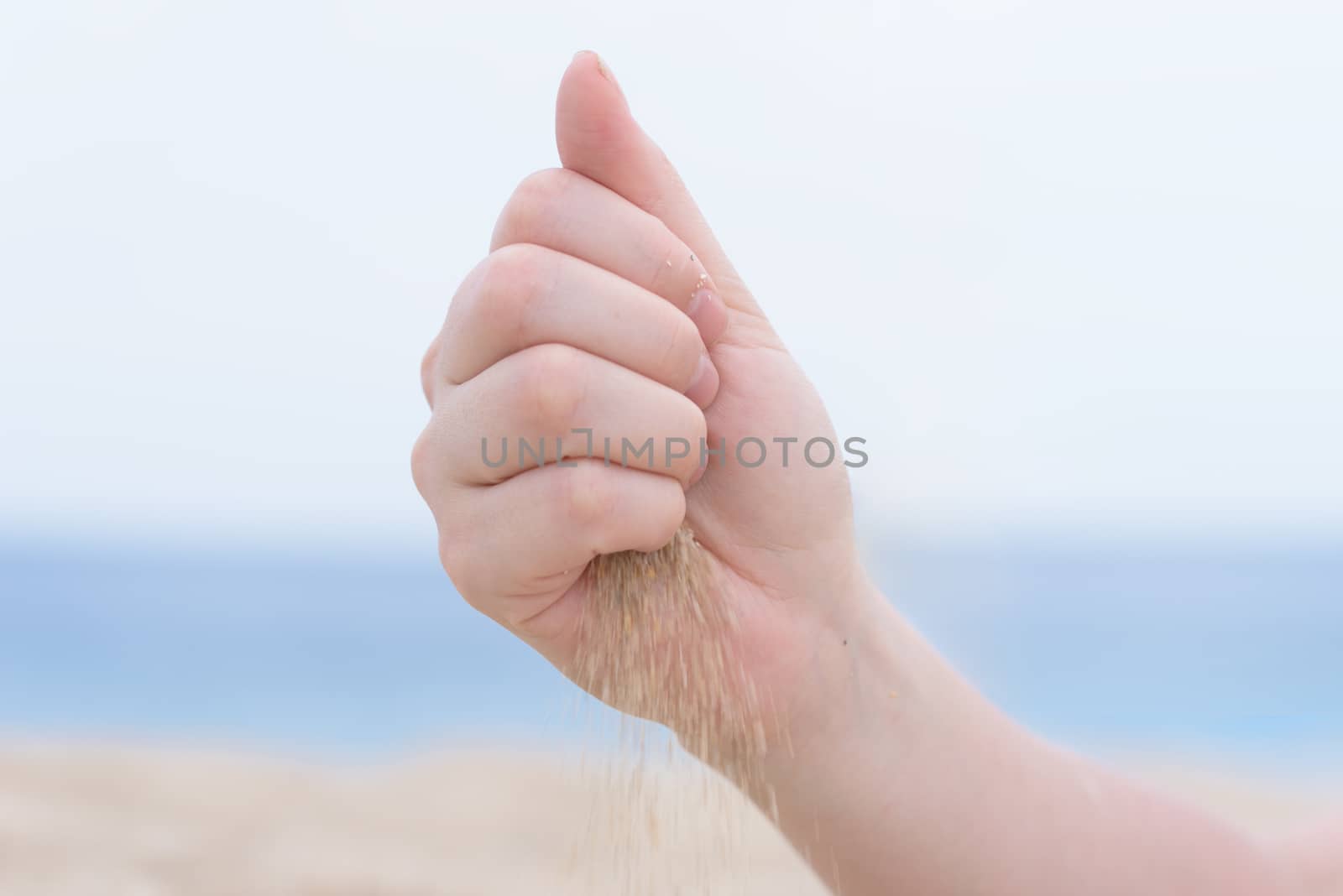 hand with sand on the beach by Visual-Content