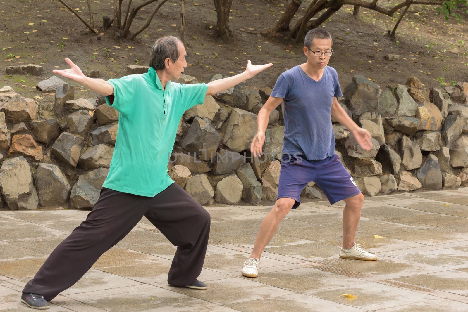 Harbin, Heilongjiang, China - September 2018: Young asian men practicing wushu on the park