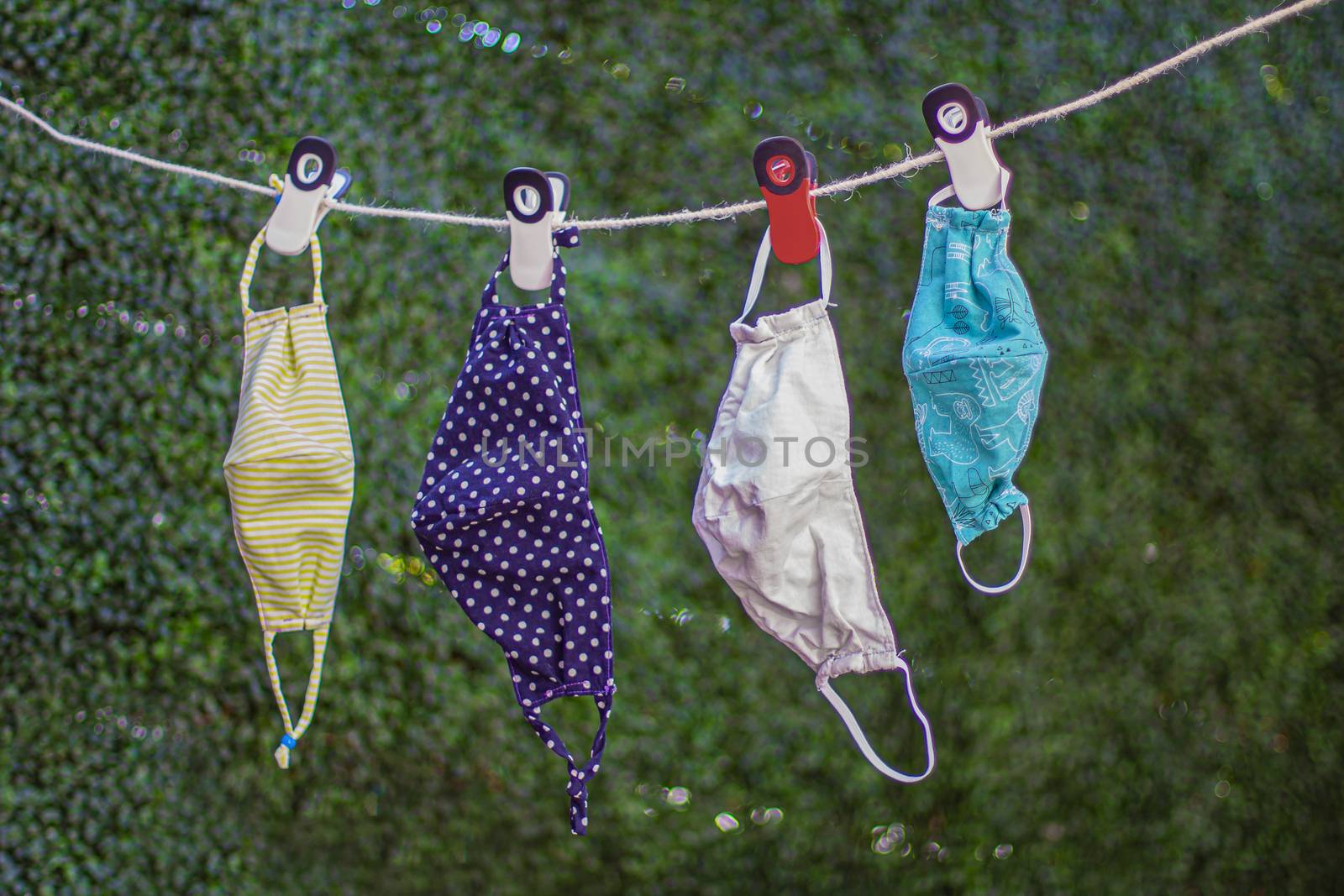 Drying outside reusable family face masks, hang on a clothesline nylon rope with clothespins.