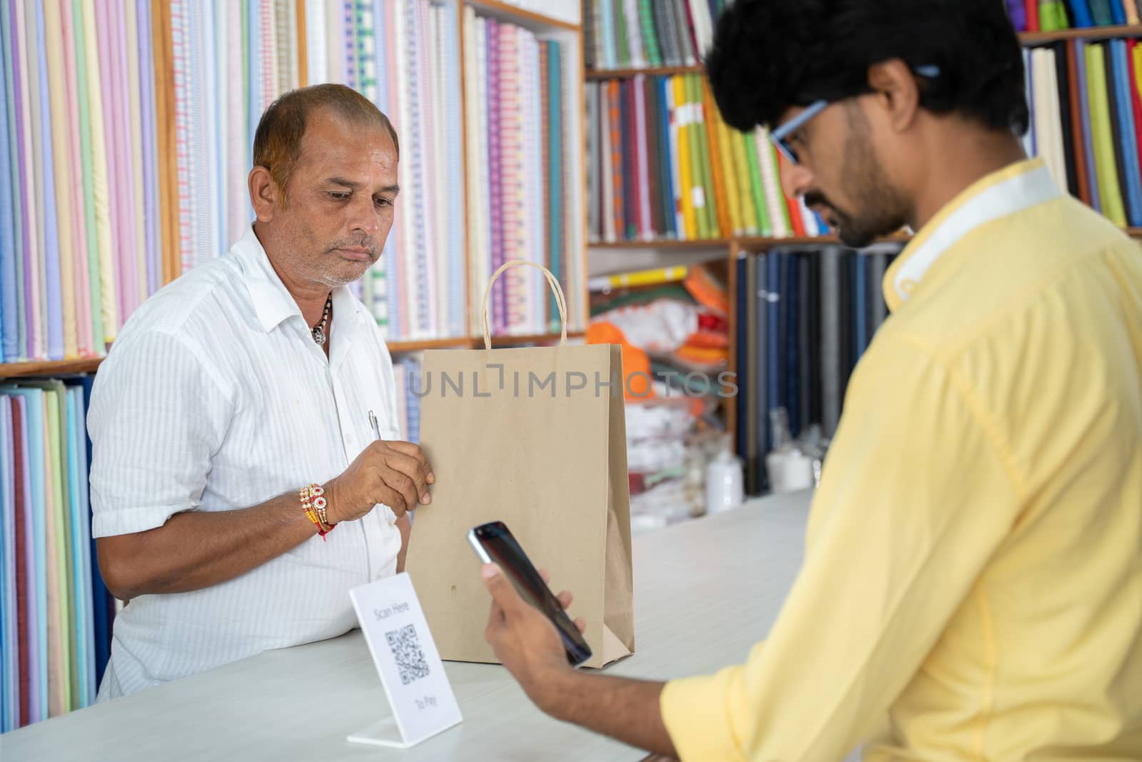 Customer using digital payment method scan to pay at cloth store to send money - concept of digital or contactless payment, e-transfer, technology and lifestyle. by lakshmiprasad.maski@gmai.com