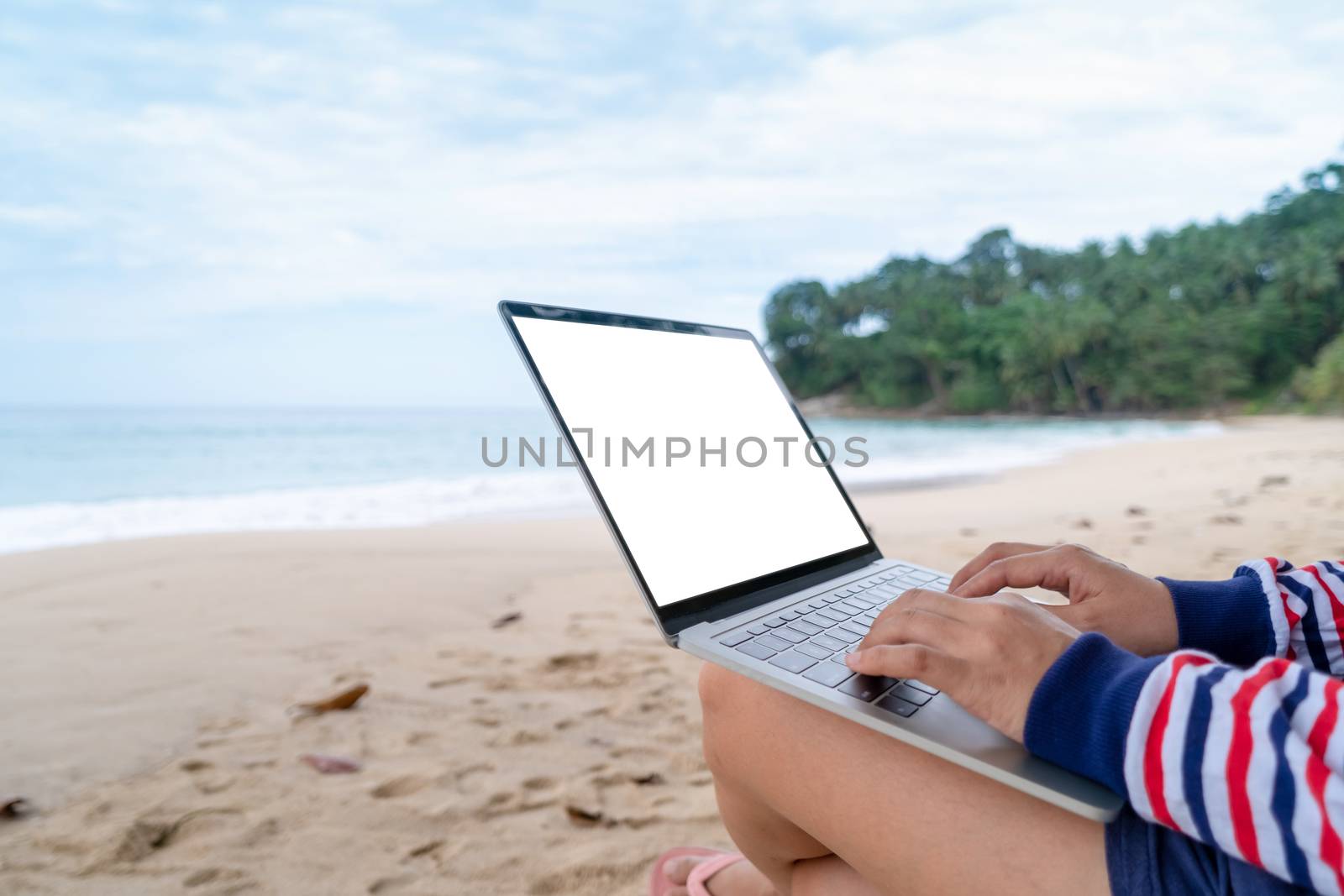 Woman using laptop and smartphone to work study in vacation day at beach background. by Suwant