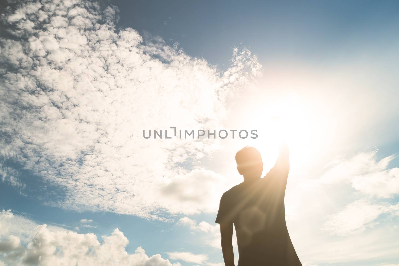 Man rise hands up to sky metaphor freedom concept with sunset sky background.