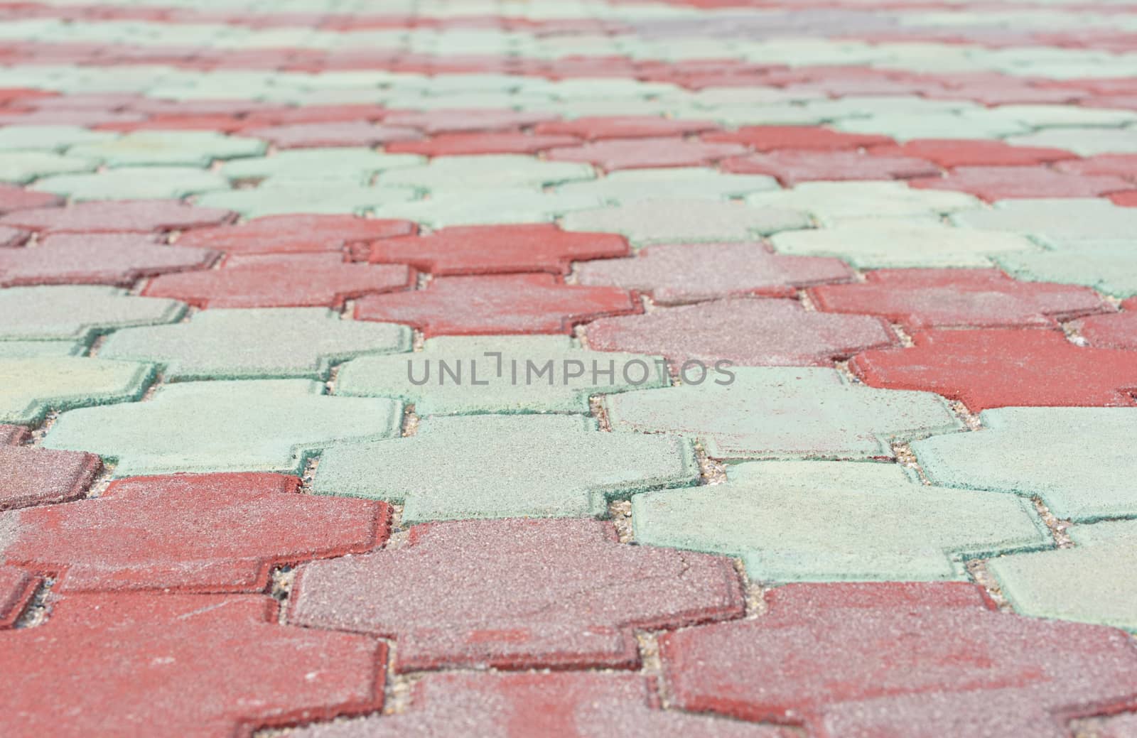 Stone pavement in perspective. Stone pavement texture. Red and green paving stones