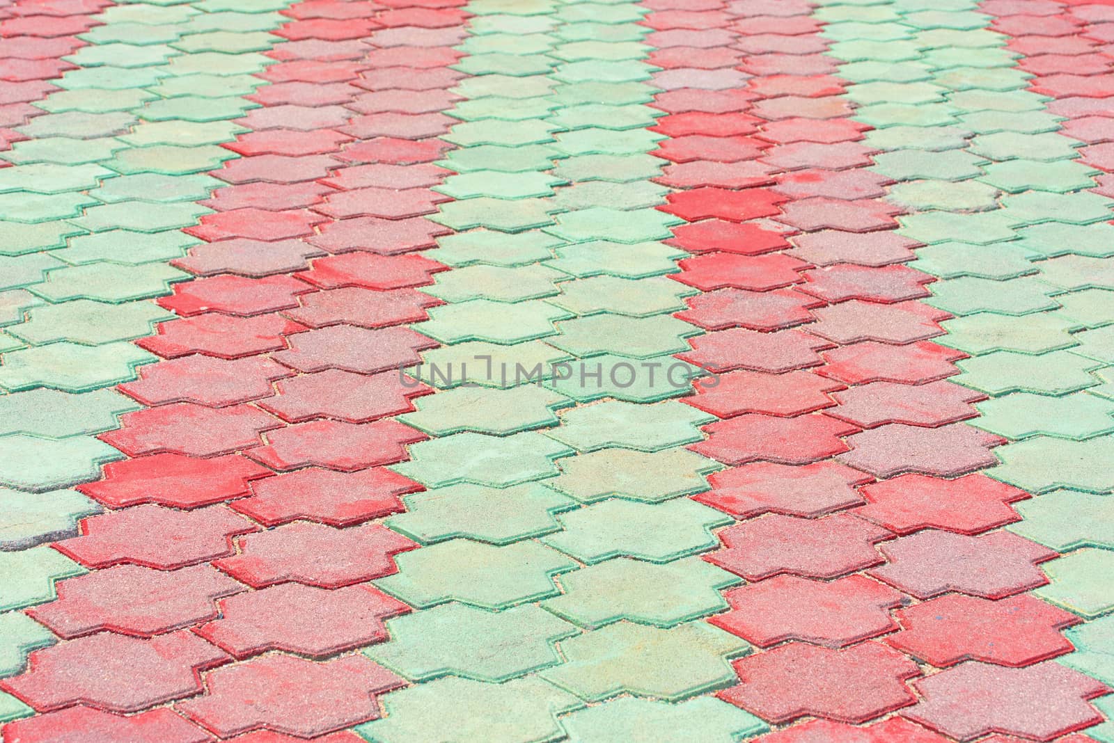 Stone pavement in perspective. Stone pavement texture. Red and green paving stones