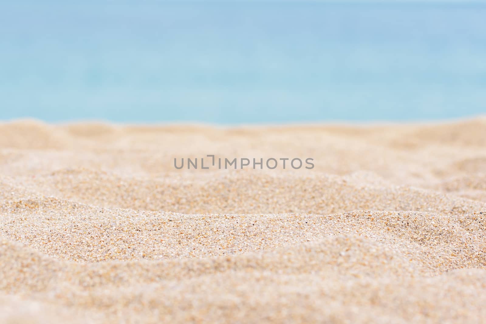 Sea sand and blue sea background. Sandy tropical beach with a blurred sea