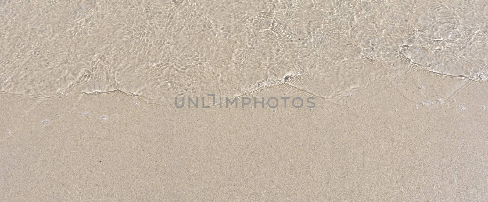 Sand texture. Sandy beach for background. Soft wave of the sea on the sandy beach