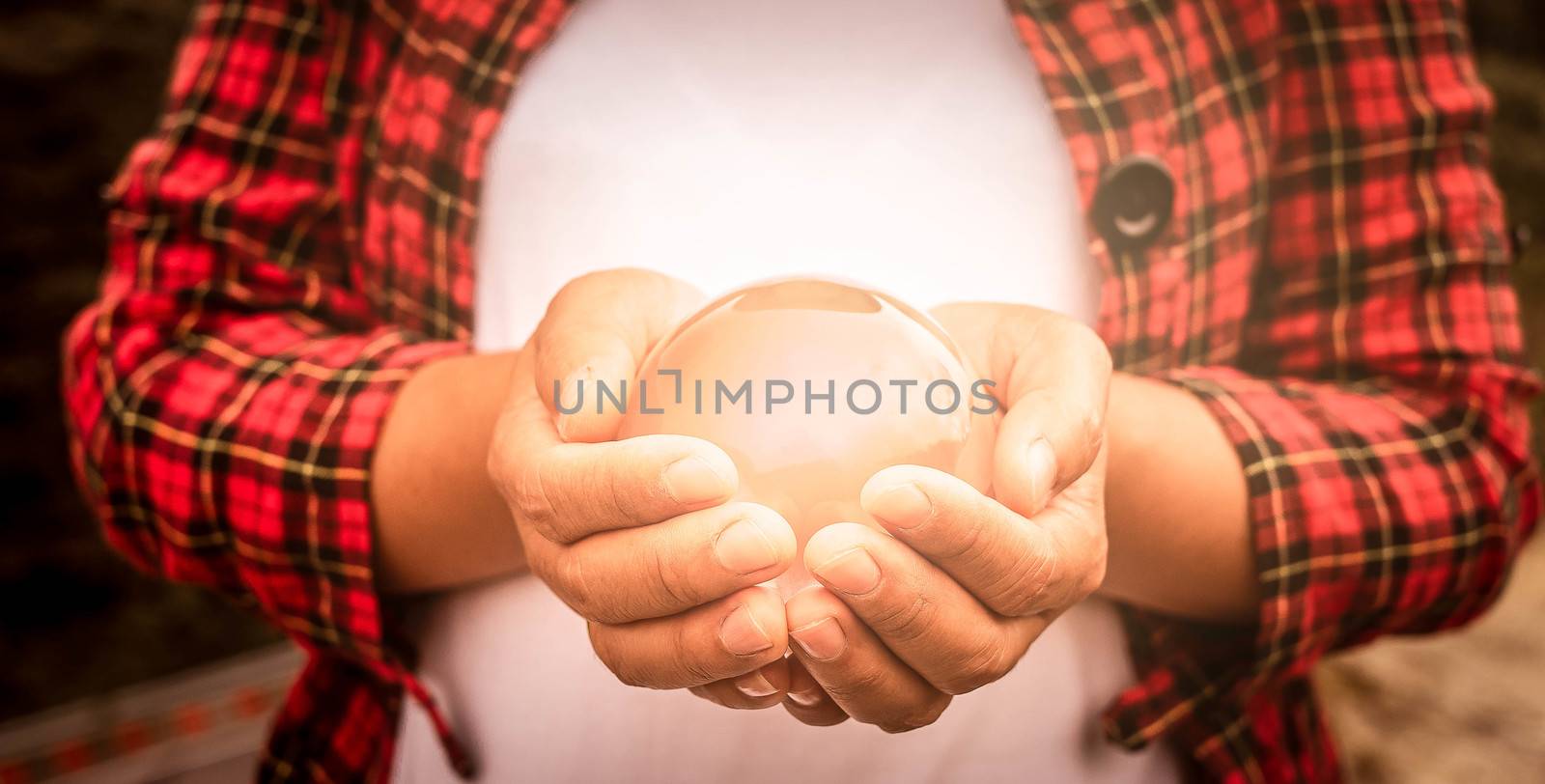 Asian woman holding a magic crystal glass ball in her hands. by TEERASAK