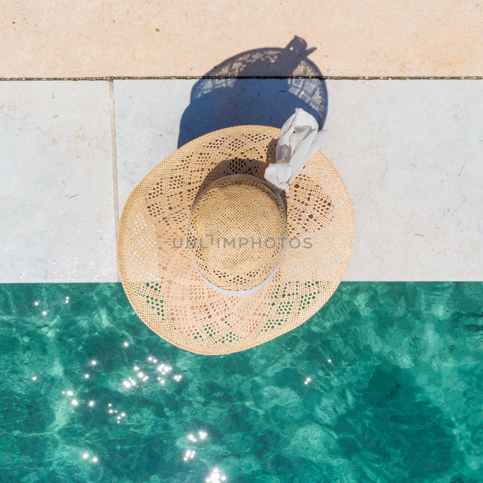 Woman wearing big summer sun hat relaxing on pier by clear turquoise sea. by kasto