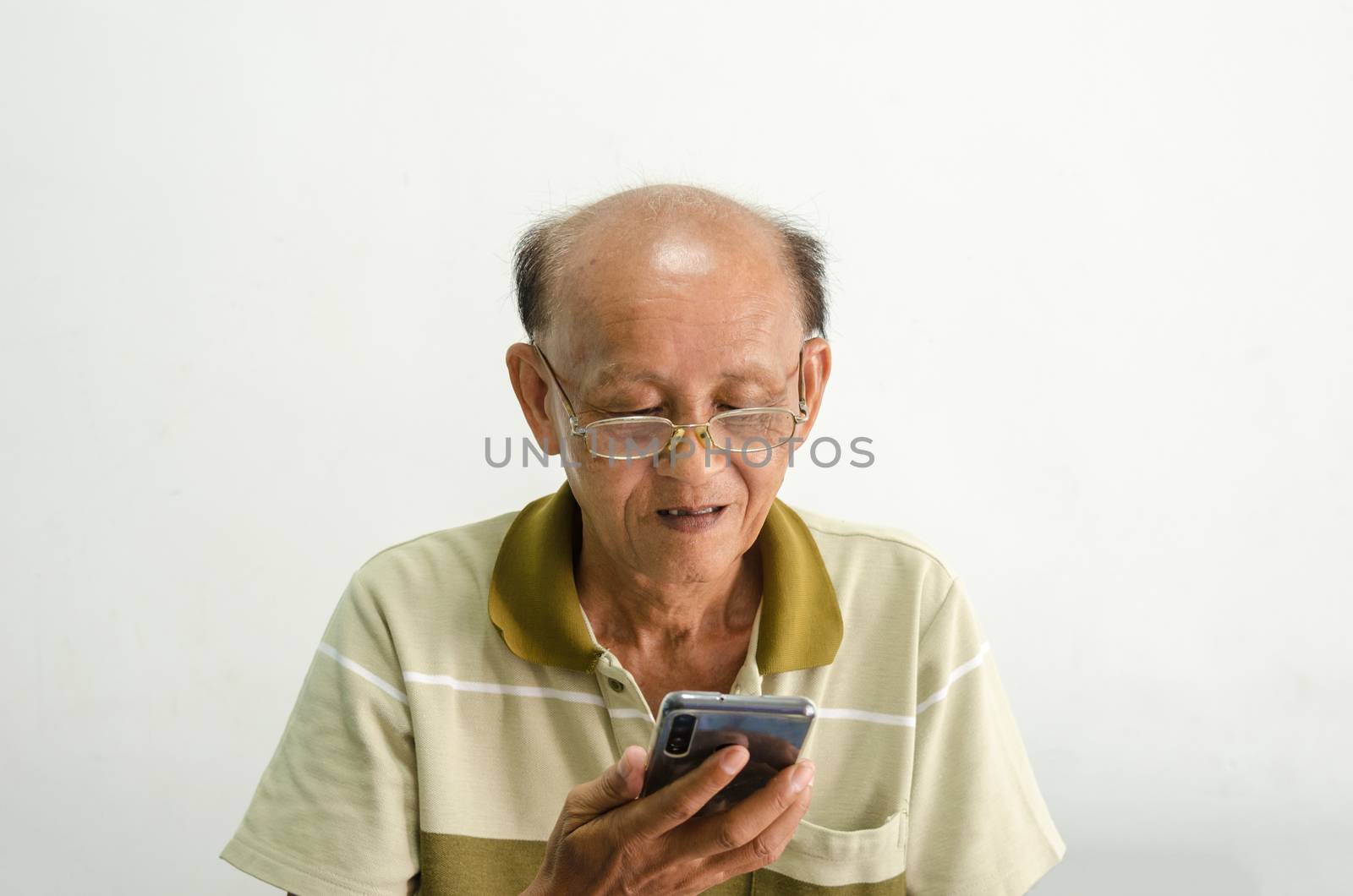 bald asian man wearing glasses is using a phone.older senior men portrait.
