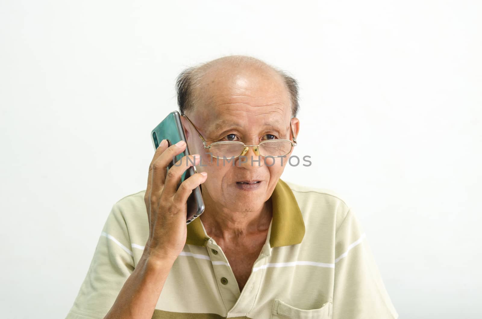 older senior men portrait.Bald Asian man wearing glasses talking on the phone