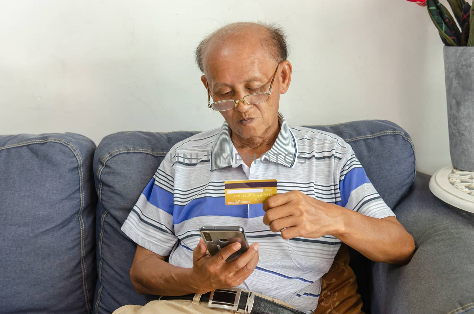 Seniors look at credit cards and mobile phones. by aoo3771