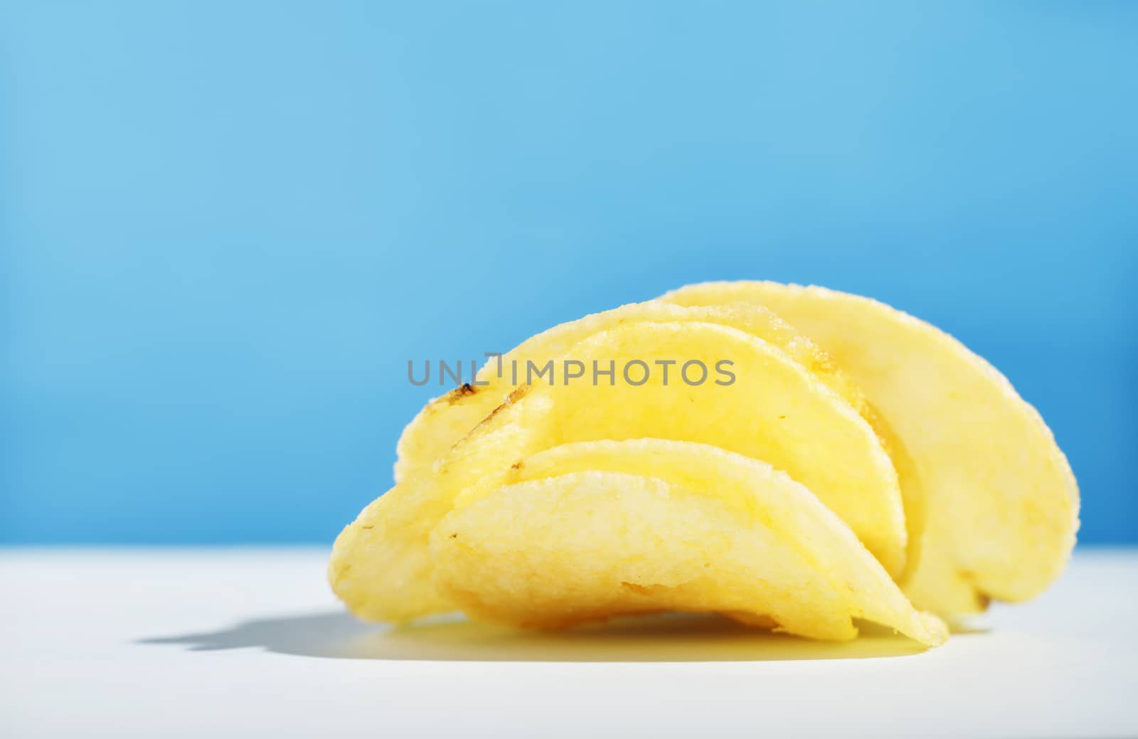 Potato chips or crisps on colored background ,beautiful slices of fried potatoes 