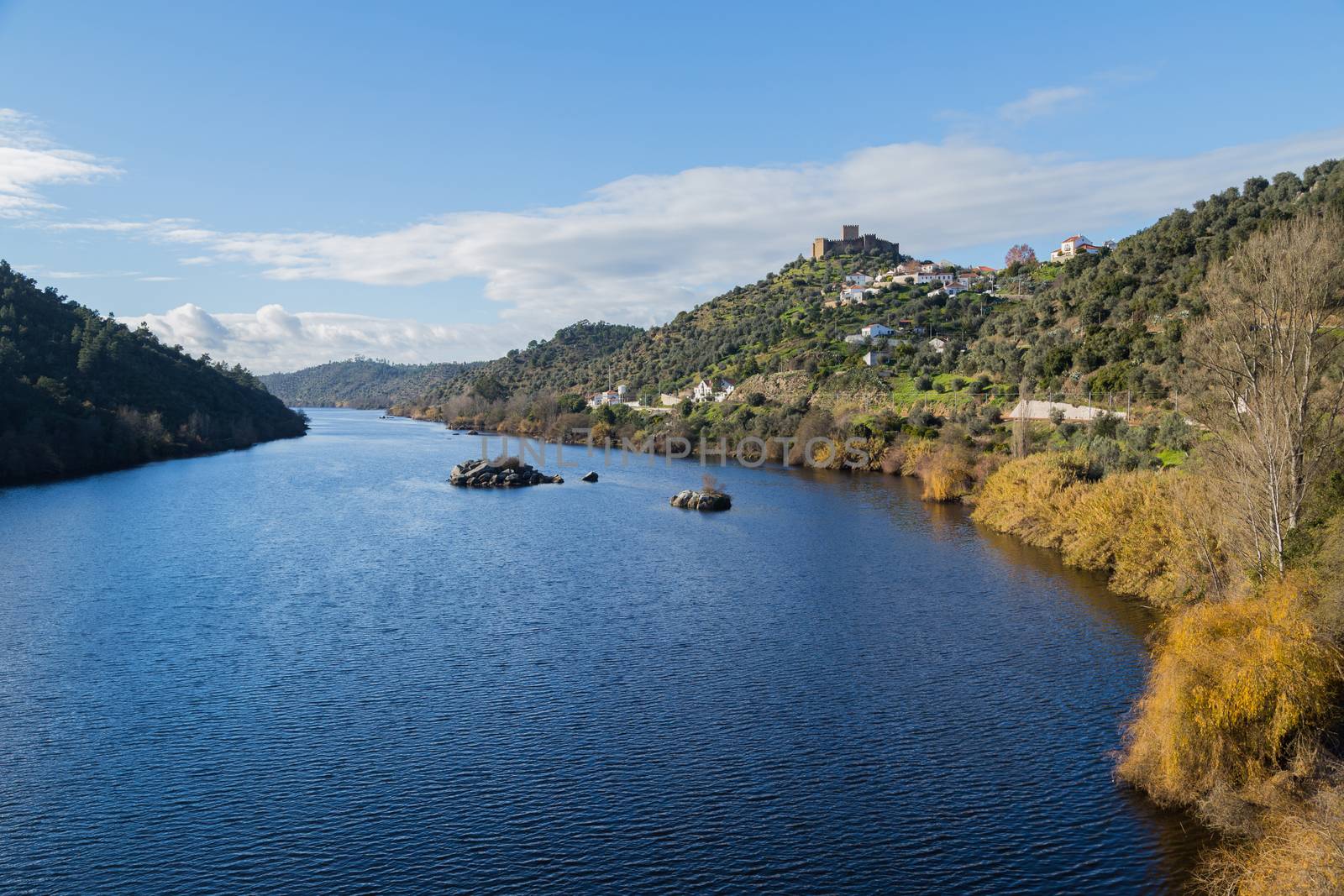 View of the Belver Castle (Castelo de Belver) and village from the middle of the Tagus River in Portugal; Concept for travel in Portugal