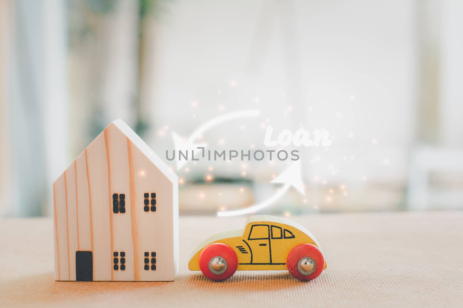 Home and car loan concept. Wooden home and car model with white arrow and loan text.