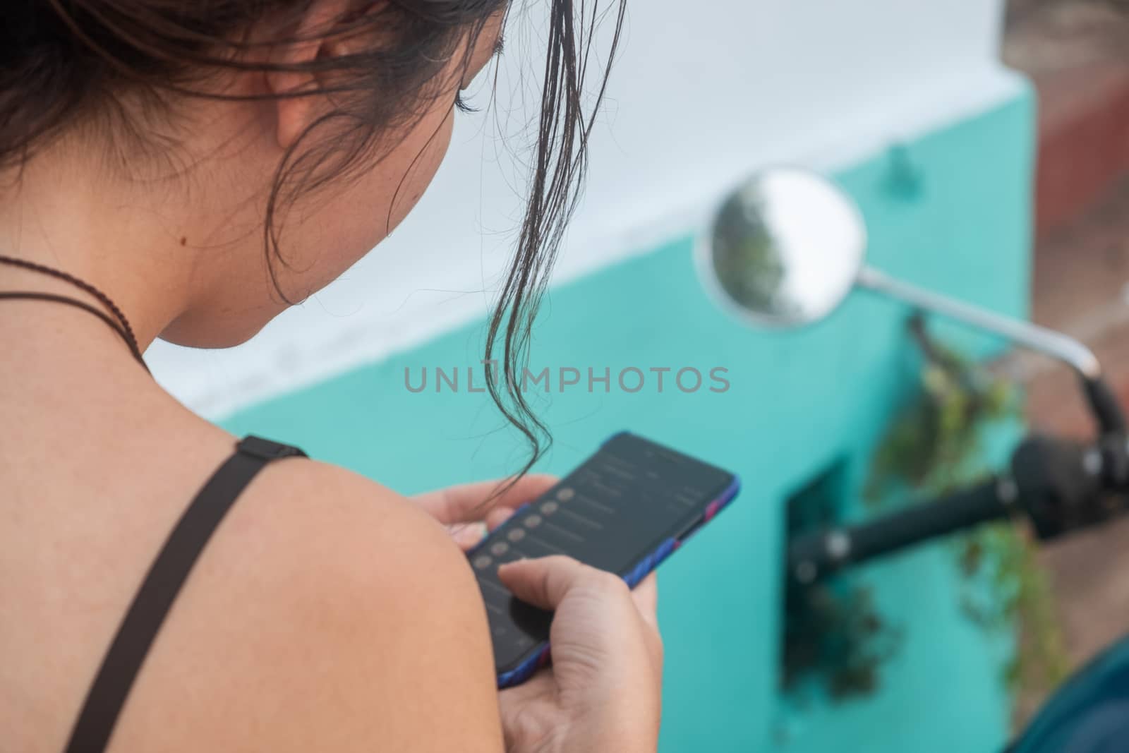 Close up portrait of woman looking in her mobile phone and checking the route