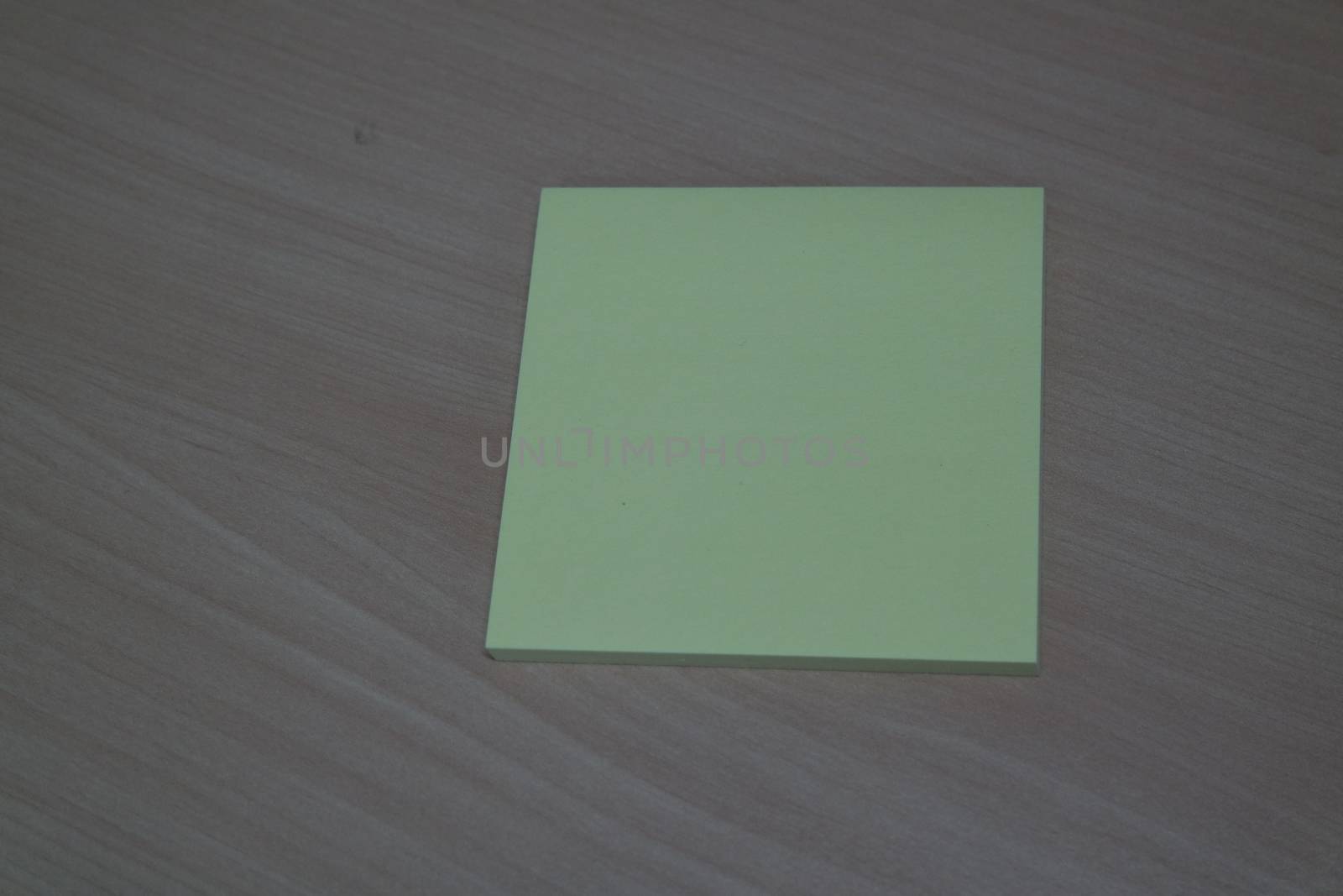 Close-up, selective focus: Yellow sticky note paper placed on a wooden table with copy space for text