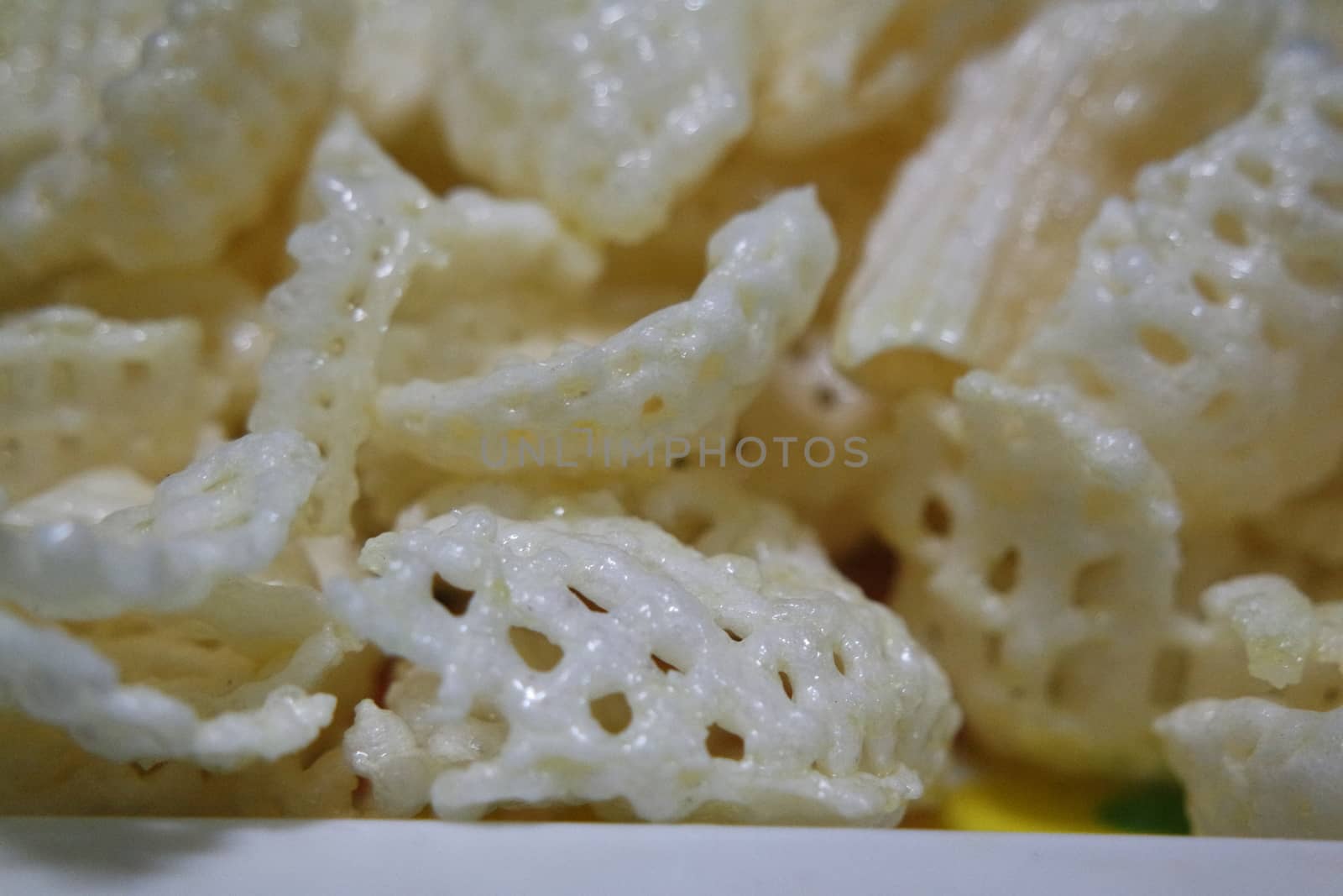 Closeup view of freshly fried chips as fast food for tea break. Potato chips with spices sprinkled on it. Fast food background for advertisements.