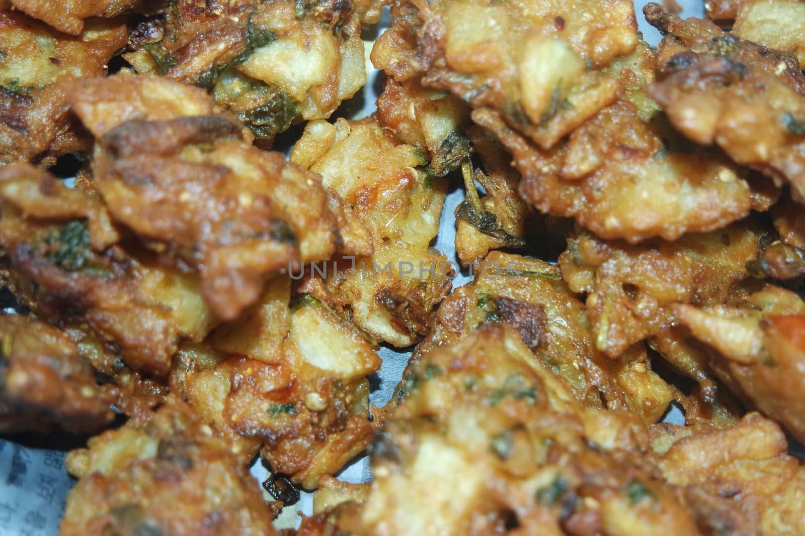 close-up view with selective focus of crispy basin pakora/pakoda or patties are popular indian or pakistani street food snack, served with green salad and sauce. Selective focus of