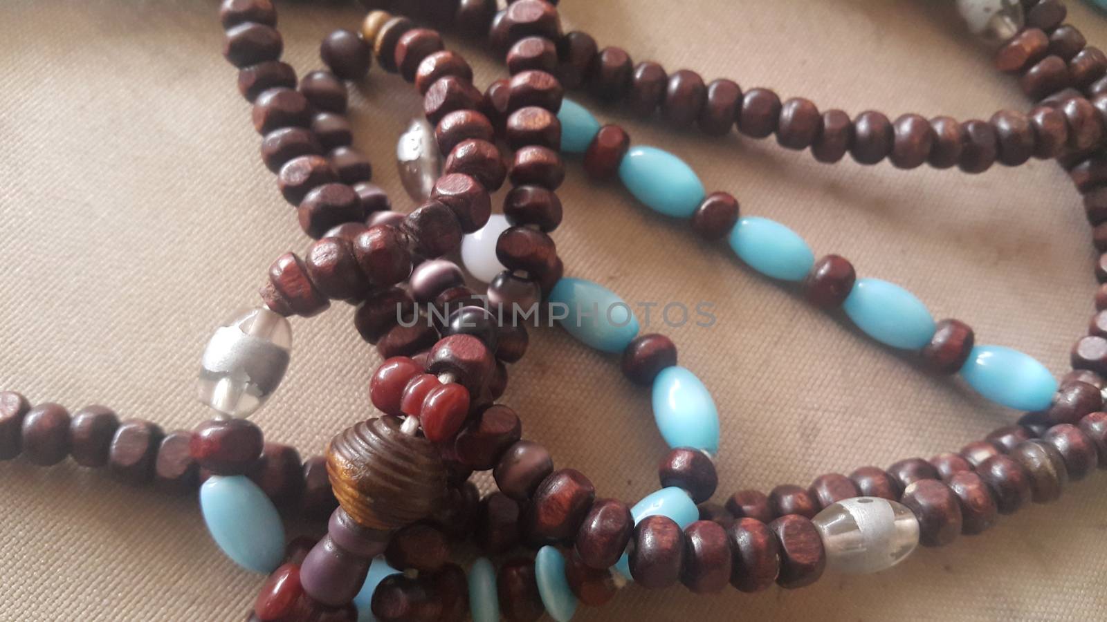 Beautiful wooden prayer beads or rosary placed over fabric background. Religion concept of ramadan or Eid for muslims.