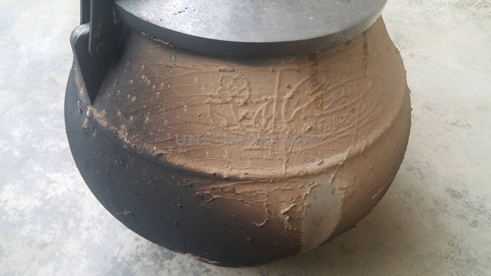 Pressure cooker covered with mud for cooking on fire. Cauldron type rural pressure cooker.