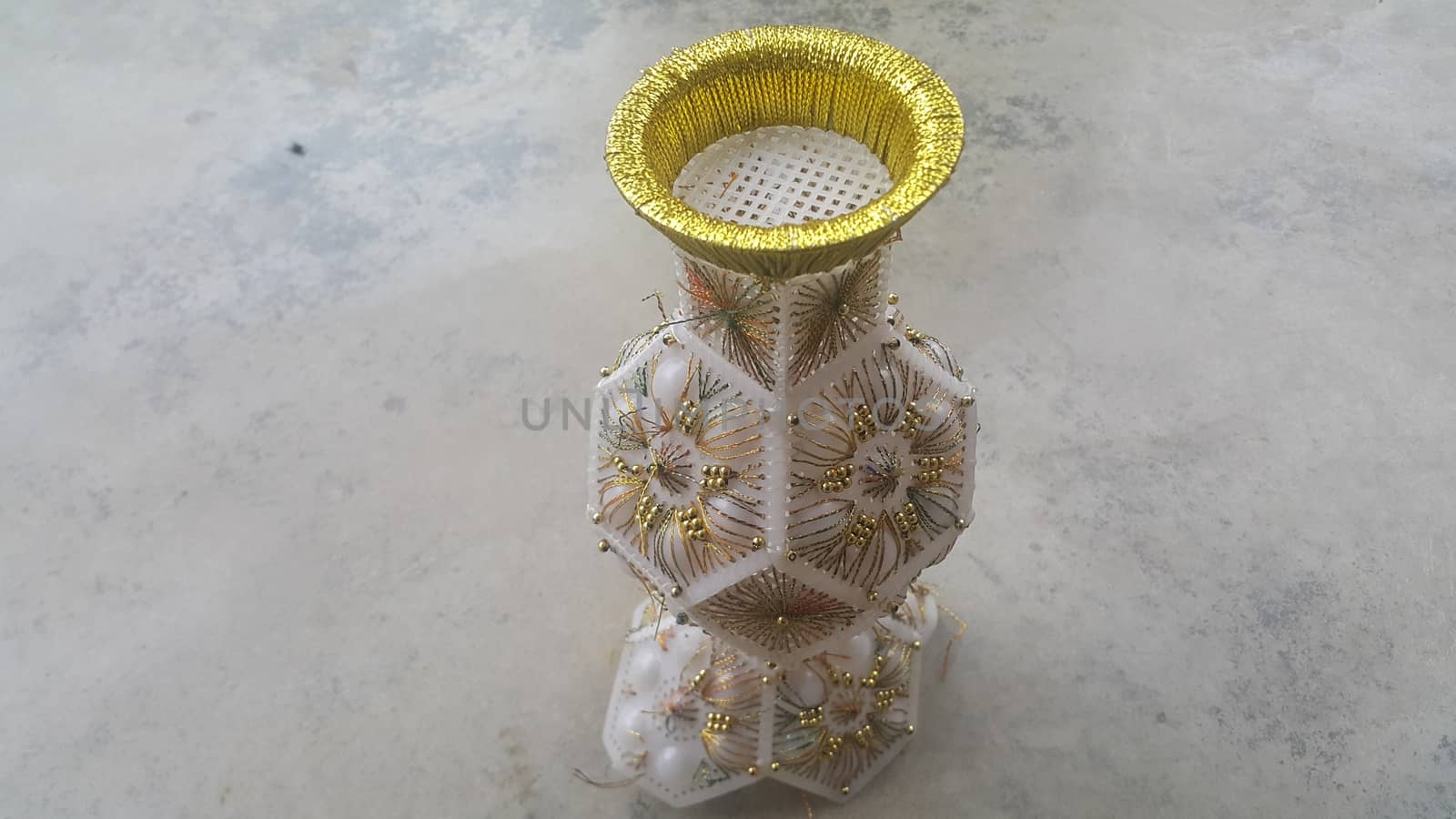 A beautiful ceramic vase placed on a grey floor used for flowers or bouquet by Photochowk
