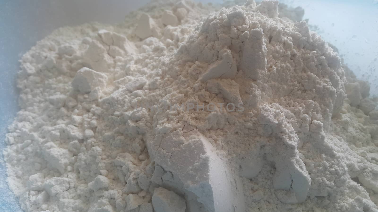Closeup view of wheat flour heap placed in market for sale. White flour background