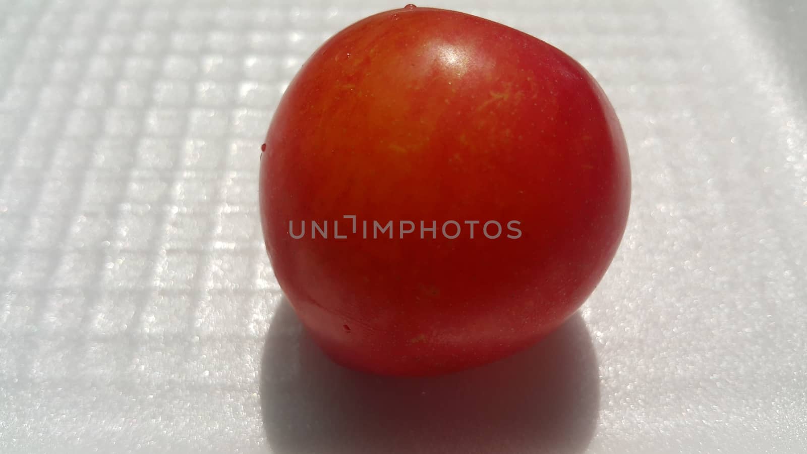 Closeup view of red plum on a white grey background. Freshly harvested plum making heart shape appearance in the view from angle.