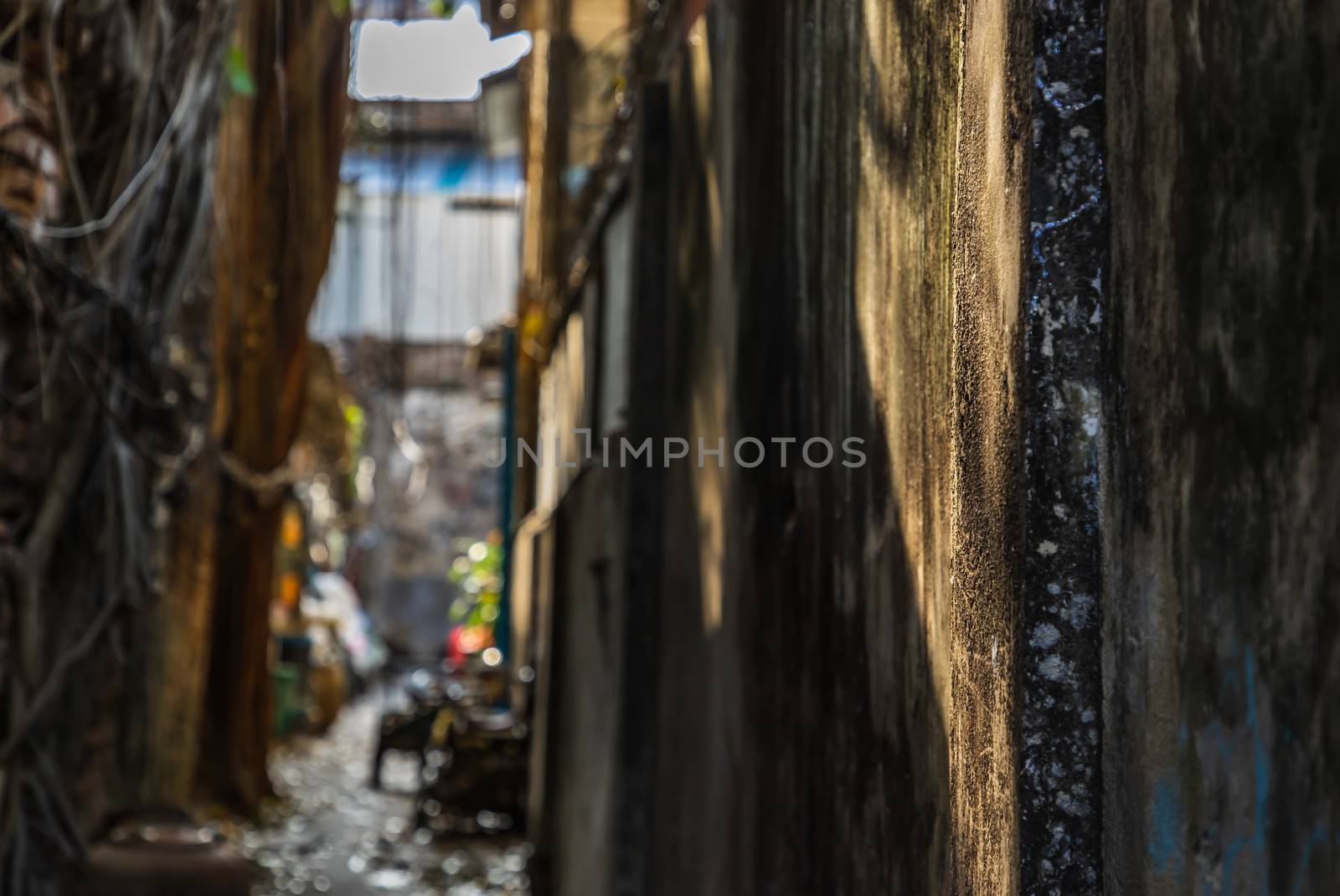 The light that shines down at the wall of narrow street in the old village. Archaeological area. Focus and blur.