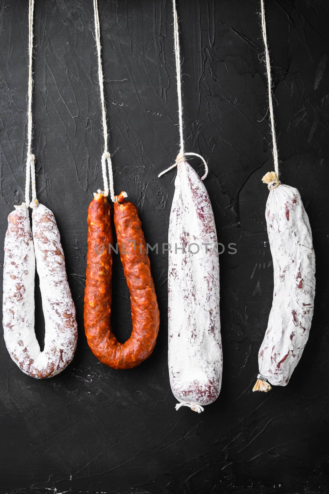 Traditional spanish sausages fuet and longaniza on black background.