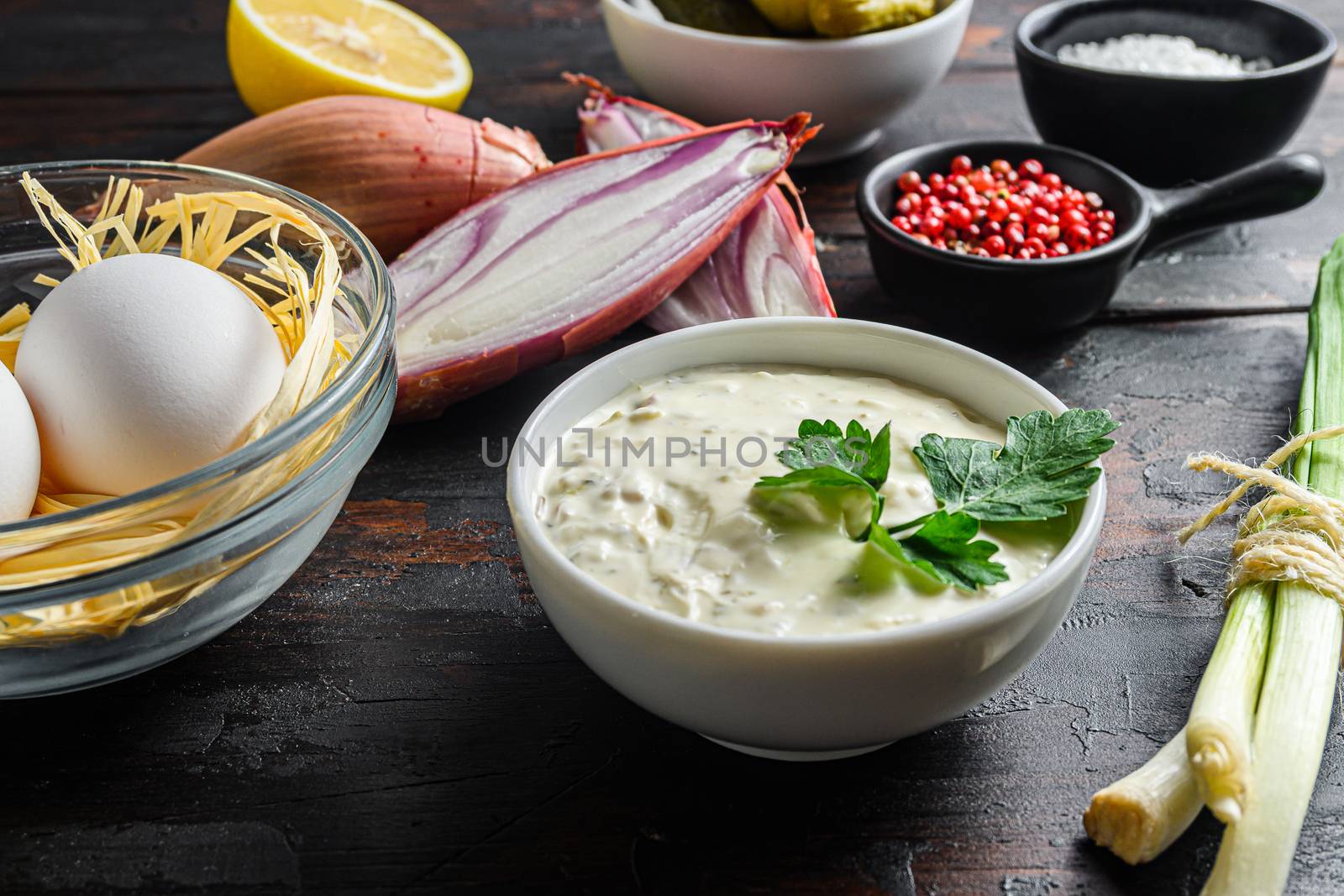 Organic Sauce Tartar . With bio ingredients capers, cucumbers, parsley, lemon and eggs. over dark wood rustic table planks side view close up new wide angle view.