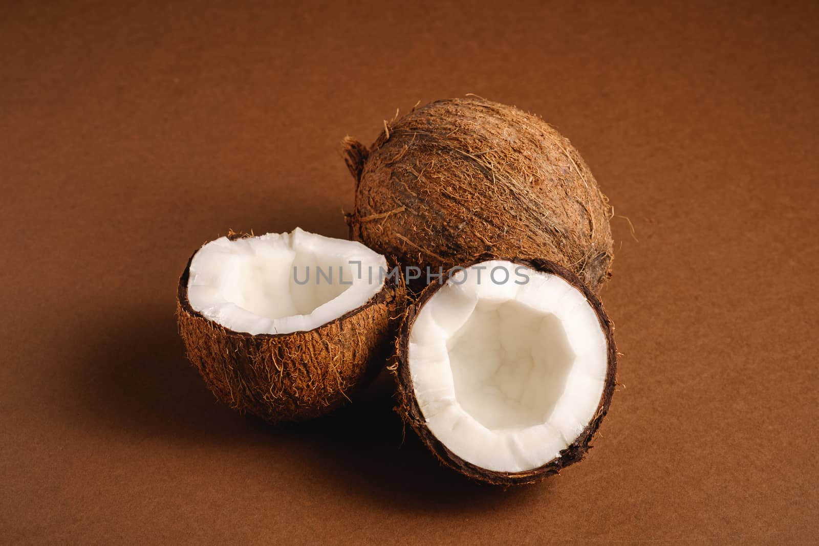 Coconut fruits on brown plain background, abstract food tropical concept, angle view